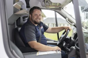 Dutch enterprises technician smiling in the front seat of a work van